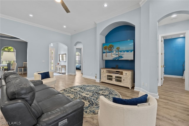 living room featuring ceiling fan, light hardwood / wood-style floors, and crown molding