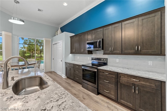 kitchen featuring pendant lighting, dark brown cabinetry, and appliances with stainless steel finishes