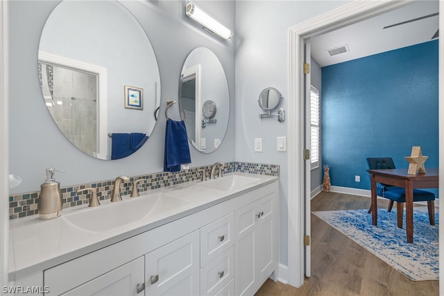 bathroom featuring hardwood / wood-style floors, vanity, and tasteful backsplash