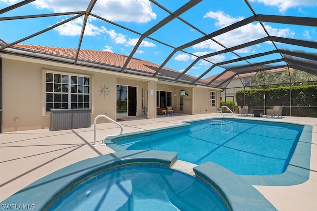 view of pool with an in ground hot tub, glass enclosure, and a patio area