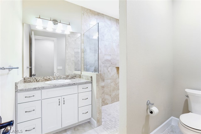 bathroom featuring toilet, vanity, and a tile shower