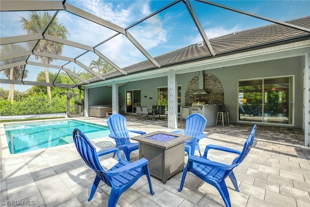 view of swimming pool with a hot tub, an outdoor kitchen, an outdoor fire pit, and a patio area