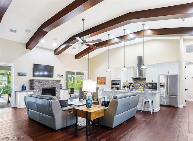 living room with ceiling fan, dark hardwood / wood-style flooring, a fireplace, high vaulted ceiling, and beam ceiling