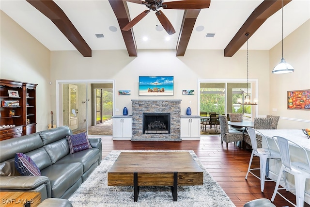 living room with beam ceiling, dark hardwood / wood-style floors, and a wealth of natural light