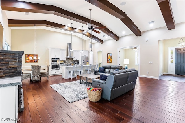 living room featuring lofted ceiling with beams, dark hardwood / wood-style floors, and ceiling fan with notable chandelier