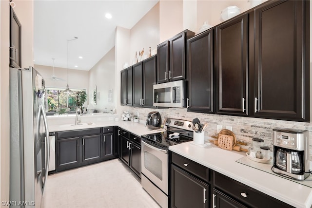 kitchen featuring decorative light fixtures, sink, appliances with stainless steel finishes, and tasteful backsplash