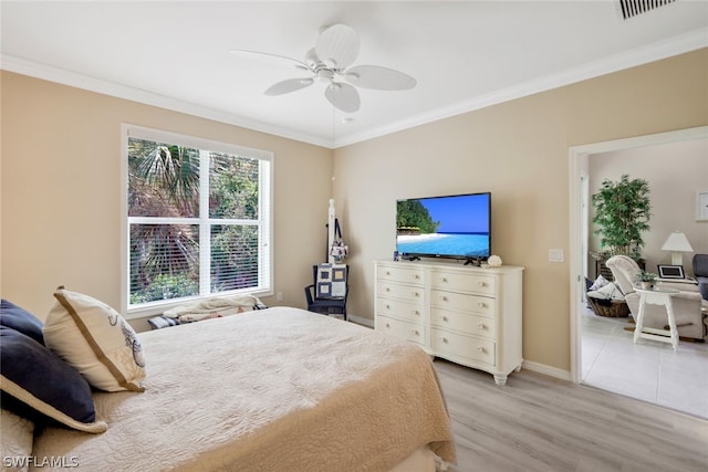 bedroom featuring ceiling fan, crown molding, and light hardwood / wood-style flooring