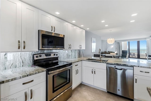 kitchen featuring appliances with stainless steel finishes, backsplash, white cabinetry, and sink