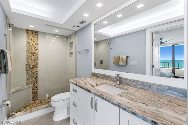 bathroom featuring a tile shower, vanity, a water view, tile patterned flooring, and toilet