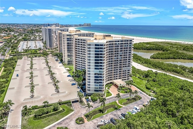 birds eye view of property featuring a water view and a beach view