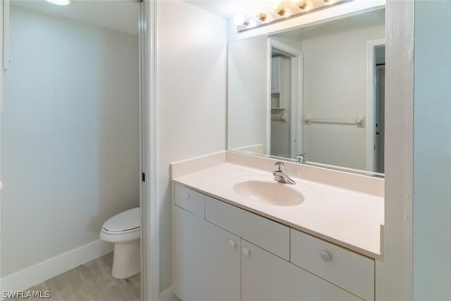 bathroom featuring vanity, toilet, and hardwood / wood-style floors