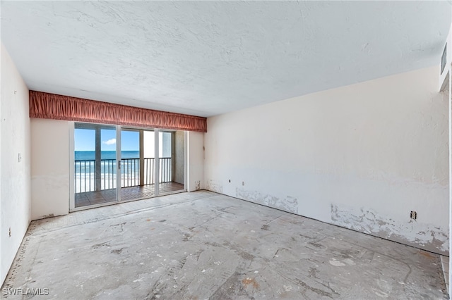 unfurnished room featuring a water view