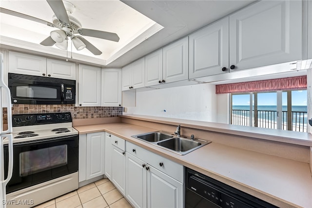 kitchen featuring black appliances, a water view, white cabinetry, and sink