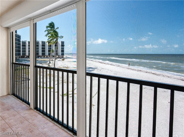 balcony featuring a beach view and a water view