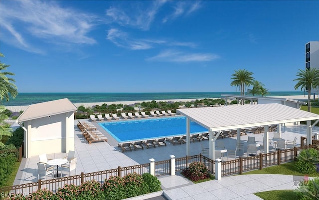 view of pool with a patio area, fence, and a water view