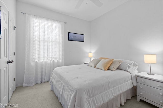 carpeted bedroom with a closet, multiple windows, and ceiling fan