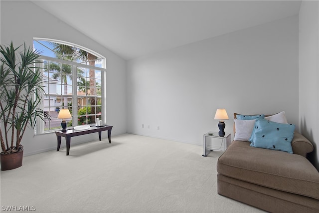 living area featuring carpet flooring, vaulted ceiling, and plenty of natural light