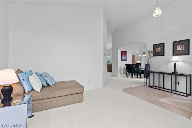 living room featuring carpet floors and a towering ceiling