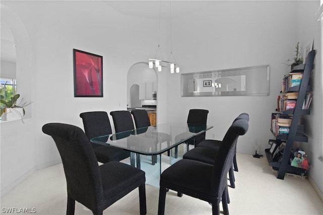 carpeted dining space featuring a chandelier