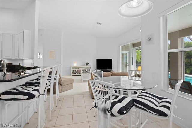 interior space with white cabinetry, a towering ceiling, and light tile patterned floors