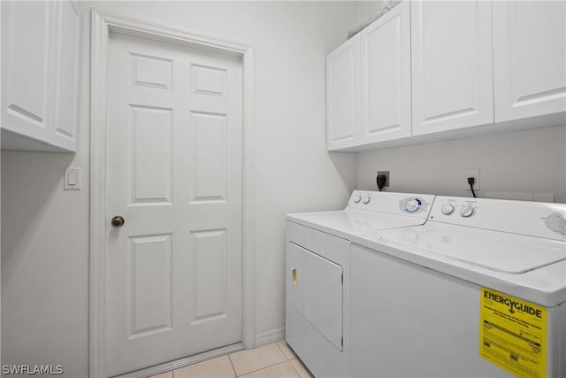 laundry area featuring light tile patterned floors, cabinets, and washing machine and clothes dryer