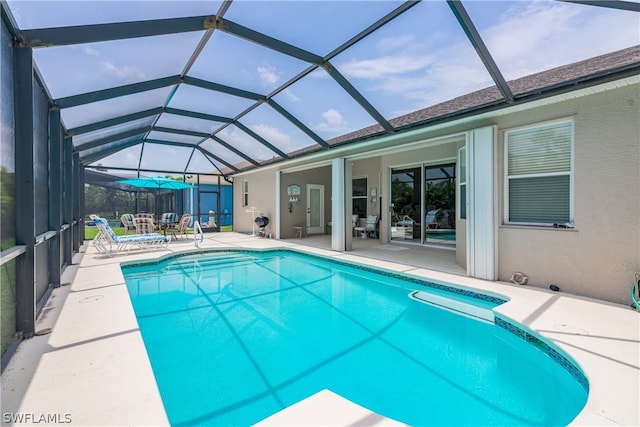 view of swimming pool featuring a patio and glass enclosure