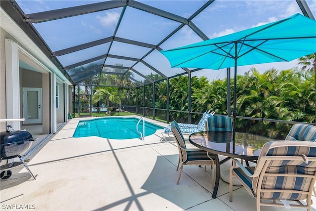 view of swimming pool featuring a patio area and glass enclosure