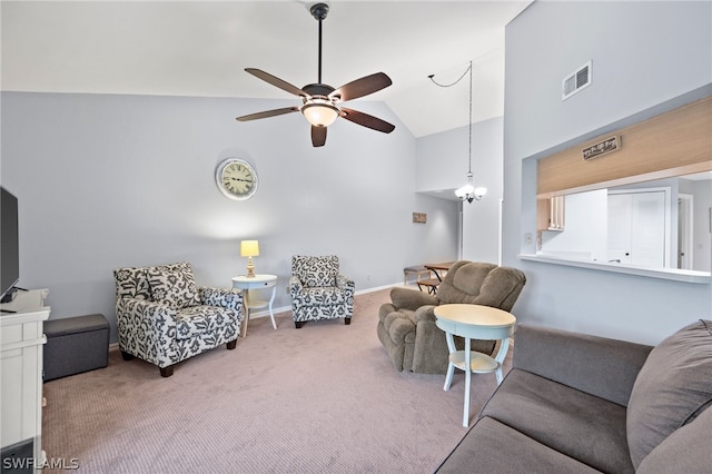 carpeted living room with lofted ceiling and ceiling fan with notable chandelier