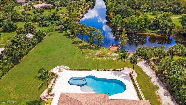 view of swimming pool with a yard, a water view, and a patio area