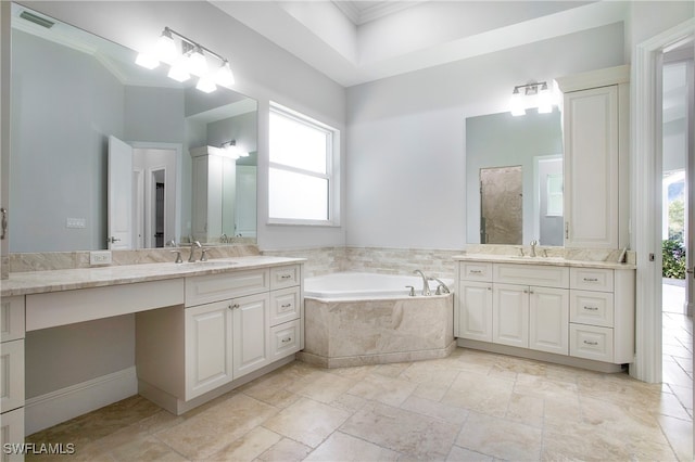 bathroom with tiled tub, vanity, and ornamental molding