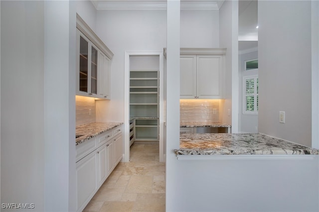 kitchen featuring light stone countertops, tasteful backsplash, and ornamental molding