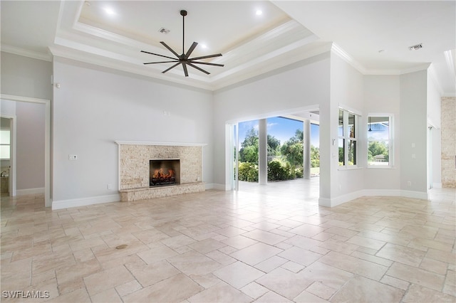 unfurnished living room with a towering ceiling, ornamental molding, a tray ceiling, and ceiling fan