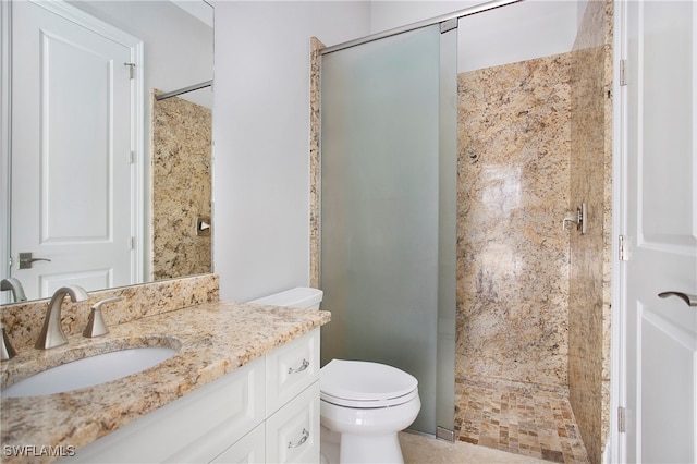 bathroom featuring vanity, toilet, and a tile shower