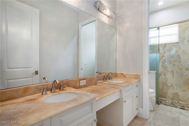 bathroom featuring vanity, toilet, and tiled shower