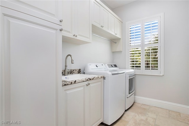 washroom featuring washing machine and clothes dryer, cabinets, and sink