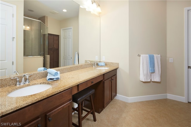 bathroom featuring a shower with door, tile patterned flooring, and dual bowl vanity