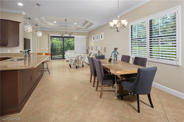 tiled dining area featuring ornamental molding, sink, plenty of natural light, and a tray ceiling