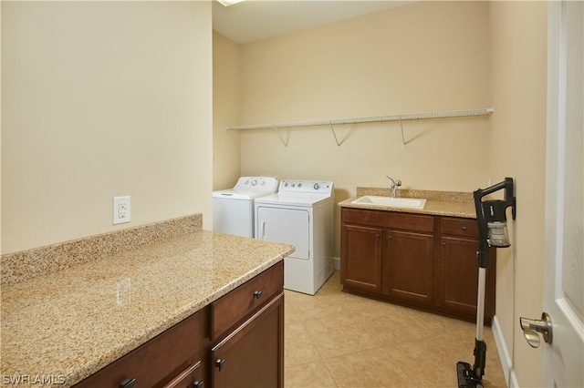 washroom featuring light tile patterned floors, independent washer and dryer, cabinets, and sink