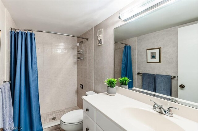 bathroom featuring toilet, vanity, and walk in shower