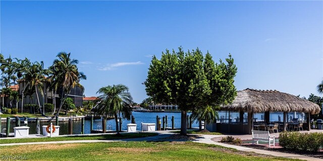 dock area with a gazebo, a lawn, and a water view