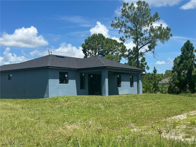 rear view of house featuring a yard