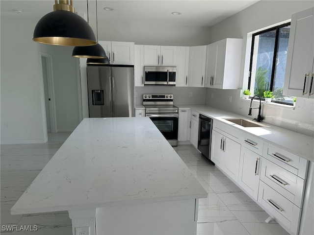 kitchen featuring a center island, white cabinetry, stainless steel appliances, decorative light fixtures, and light stone counters