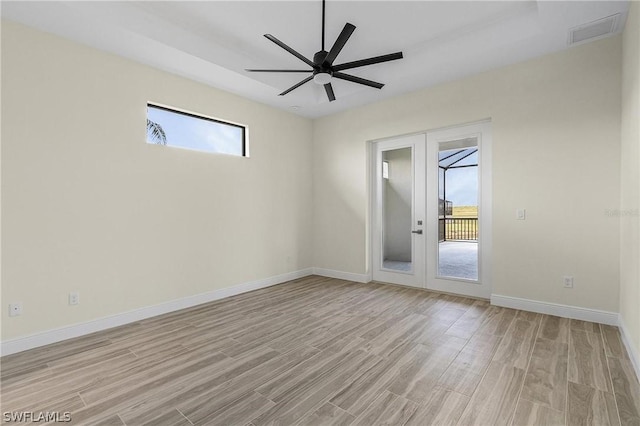 unfurnished room with french doors, light wood-type flooring, and ceiling fan