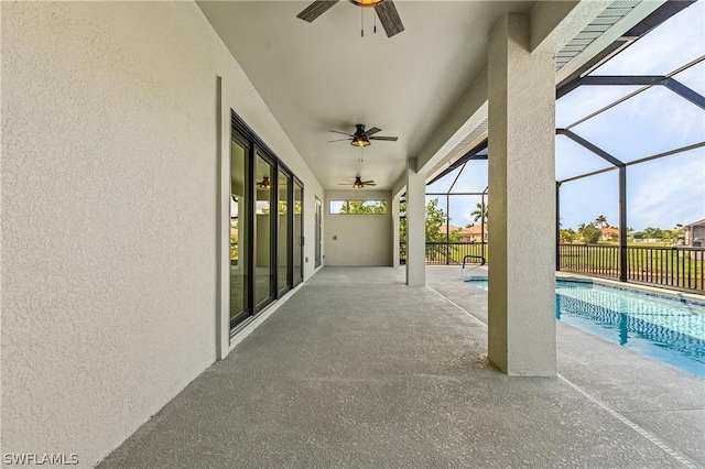 view of patio with glass enclosure, a fenced in pool, and ceiling fan