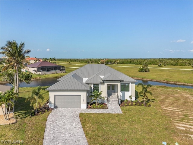 view of front of home with a water view, a garage, and a front lawn