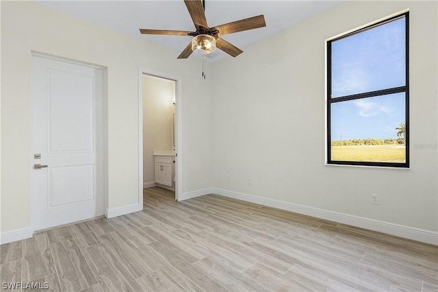 unfurnished bedroom with connected bathroom, light hardwood / wood-style flooring, and ceiling fan