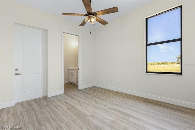 unfurnished bedroom featuring light wood-type flooring and ensuite bath