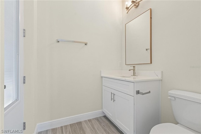 bathroom featuring vanity, toilet, and hardwood / wood-style floors