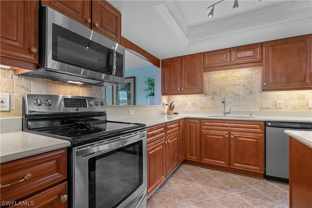 kitchen featuring a tray ceiling, stainless steel appliances, light tile patterned flooring, and tasteful backsplash