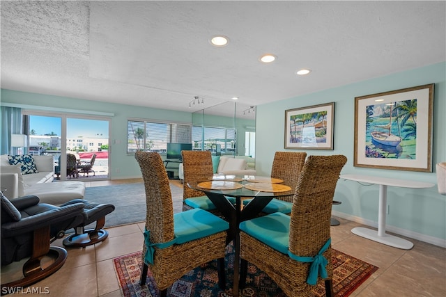 dining space featuring light tile patterned flooring and a textured ceiling